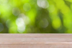 Wood table top on bokeh green background photo