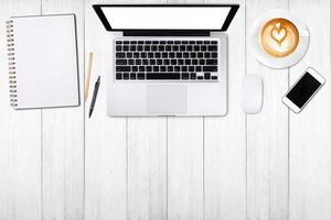 Top view laptop computer or notebook,mobile phone and cup of latte art coffee on wooden table. Business template mock up for adding your text. photo