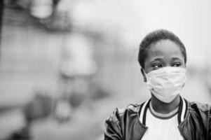 niña africana en el parque con máscaras médicas para protegerse de infecciones y enfermedades cuarentena del virus del coronavirus. foto