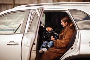 joven madre e hijo en coche. concepto de conducción segura. foto