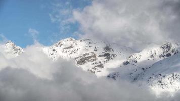 8k imponerande höga snöiga bergstoppar bakom molnen video