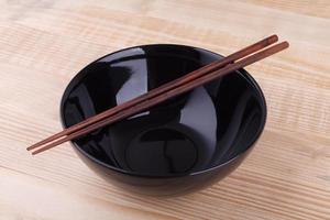 Chopsticks in asian set table on wood background photo