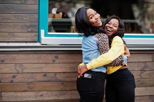 dos jóvenes amigas universitarias afroamericanas se abrazan. foto