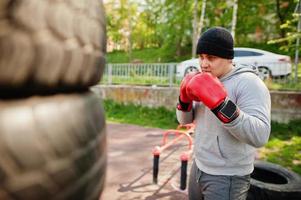 Man arabian boxer in hat training for a hard fight outdoor gym. photo