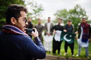 Group of pakistani man wearing traditional clothes salwar kameez or kurta with Pakistan flags. photo