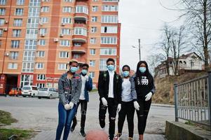 grupo de amigos adolescentes africanos contra la calle vacía con un edificio que usa máscaras médicas para protegerse de infecciones y enfermedades cuarentena del virus del coronavirus. foto
