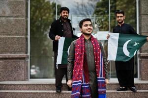 Group of pakistani man wearing traditional clothes salwar kameez or kurta with Pakistan flags. photo