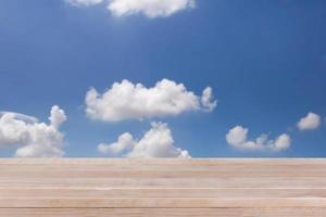 brown wood table top on bokeh abstract blue sky background - can be used for montage or display your products photo