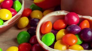 Beautiful red and yellow tulips for easter holiday. Chocolate eggs and candies on wooden background. video