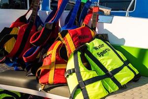 coloridos chalecos salvavidas listos en bote antes de la excursión de deportes acuáticos foto