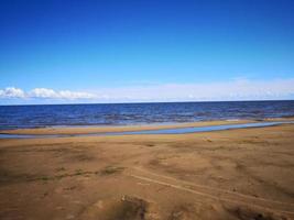 Large sandy beach on the shore of the sea or lake photo