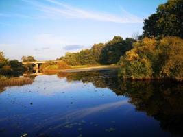 A river or lake surrounded by trees photo