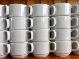 the arrangement of ceramic glasses neatly lined up on a shelf photo