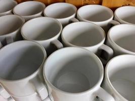 the arrangement of ceramic glasses neatly lined up on a shelf photo