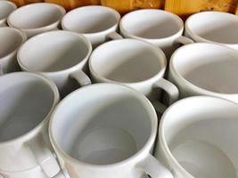 the arrangement of ceramic glasses neatly lined up on a shelf. photo