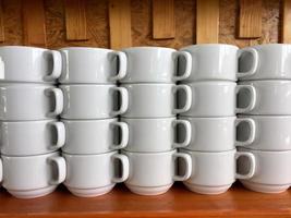 the arrangement of ceramic glasses neatly lined up on a shelf. photo