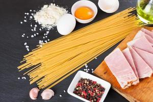 ingredientes para pasta carbonara sobre fondo de pizarra negra foto