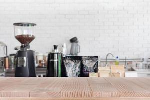 la parte superior de la mesa de madera en el fondo abstracto de la cafetería borrosa - se puede utilizar para montar o mostrar sus productos foto