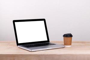 Front view of the laptop and take-out coffee  is on the work table concrete background photo