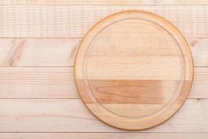 empty round cutting board on wood background photo