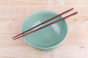 Chopsticks in asian set table on wood background photo