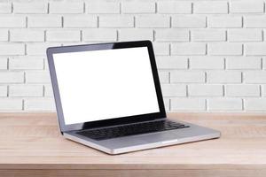 Front view of the laptop is on the work table brick background photo