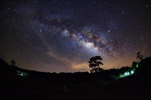 Beautiful milky way galaxy on a night sky and silhouette of tree with cloud, Long exposure photograph.with grain photo