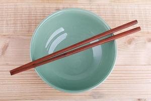 Chopsticks in asian set table on wood background photo