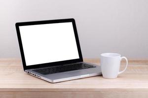 Front view of the laptop and coffee is on the work table concrete background photo