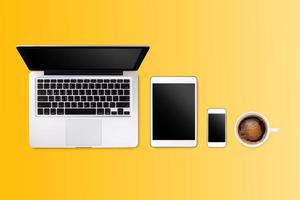 Laptop tablet smartphone  and coffee on yellow background with text space and copy space photo