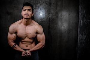 retrato de hombre asiático con gran músculo en el gimnasio, gente de tailandia, entrenamiento para una buena salud, entrenamiento de peso corporal, fitness en el concepto de gimnasio foto