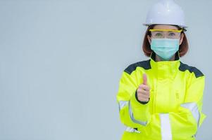 bella ingeniera asiática usa traje, anteojos y casco de fondo blanco, gente tailandesa foto