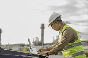Asian man petrochemical engineer working at oil and gas refinery plant industry factory,The people worker man engineer work control at power plant energy industry manufacturing photo