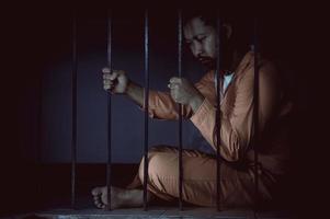 hombre asiático desesperado en la prisión de hierro, concepto de prisionero, gente tailandesa, esperanza de ser libre, prisioneros serios encarcelados en la prisión foto