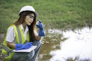 los ingenieros ambientales inspeccionan la calidad del agua, llevan el agua al laboratorio para su análisis, verifican el contenido de minerales en el agua y el suelo, verifican los contaminantes en las fuentes de agua. foto