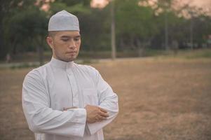 oración del hombre islámico asiático, oración musulmana joven, concepto del festival de ramadán foto