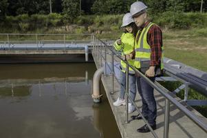 los ingenieros ambientales trabajan en plantas de tratamiento de aguas residuales, la ingeniería de suministro de agua trabaja en la planta de reciclaje de agua para su reutilización, los técnicos y los ingenieros discuten el trabajo juntos. foto