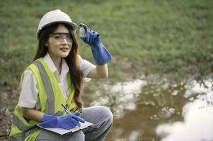 los ingenieros ambientales inspeccionan la calidad del agua, llevan el agua al laboratorio para su análisis, verifican el contenido de minerales en el agua y el suelo, verifican los contaminantes en las fuentes de agua. foto