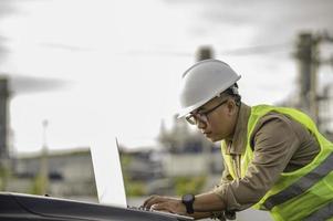 Asian man petrochemical engineer working at oil and gas refinery plant industry factory,The people worker man engineer work control at power plant energy industry manufacturing photo