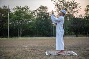 oración del hombre islámico asiático, oración musulmana joven, concepto del festival de ramadán foto