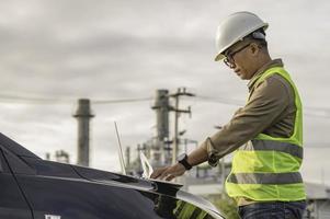 ingeniero petroquímico asiático que trabaja en la fábrica de la industria de la planta de refinería de petróleo y gas, el trabajador de la gente ingeniero controla el trabajo en la fabricación de la industria energética de la planta de energía foto