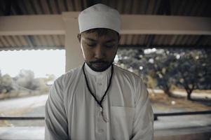 oración del hombre islámico asiático, oración musulmana joven, concepto del festival de ramadán foto