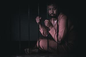 Asian man desperate at the iron prison,prisoner concept,thailand people,Hope to be free,Serious prisoners imprisoned in the prison photo