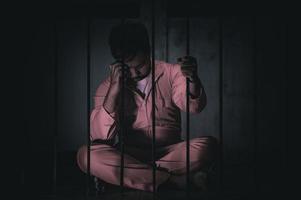 Asian man desperate at the iron prison,prisoner concept,thailand people,Hope to be free,Serious prisoners imprisoned in the prison photo