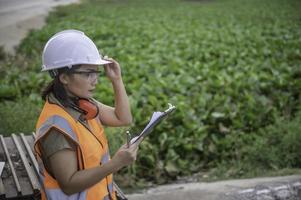 los ingenieros ambientales trabajan en la planta de almacenamiento de agua, verifican el ph del agua, verifican la calidad del agua. foto