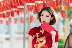 retrato hermosa mujer asiática en vestido cheongsam, gente de tailandia, concepto de feliz año nuevo chino, dama asiática feliz en vestido tradicional chino foto