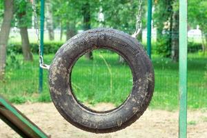 Suspended car tire wheel in dog park photo