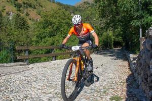 Italy  2022 Cyclists traveling on challenging trails on mountain bikes photo