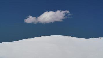 8k cumuluswolk uit één stuk in blauwe lucht op helder besneeuwd land video