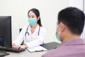 Asian woman doctor is typing on keyboard to record information photo